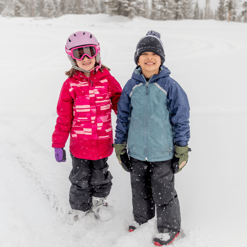 deux jeunes souriant dans la neige