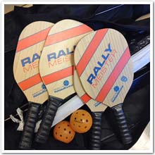 Image of pickleball raquets, balls and a net.