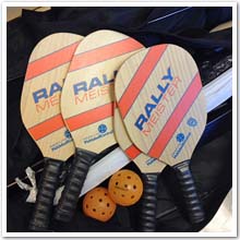 Image de raquettes, de balles et un filet de Pickleball.