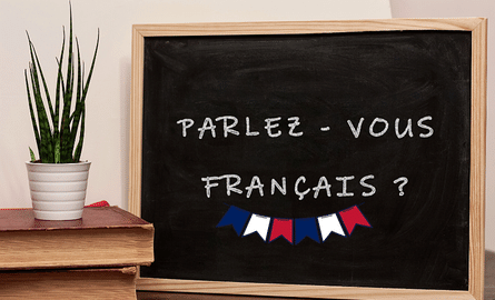 parlez-vous le français écrit sur un tableau noir.