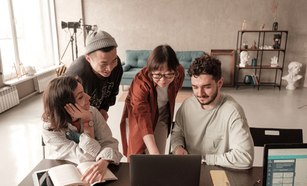 people working together, looking at a computer screen