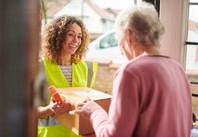 woman delivering a package with books to an older person 